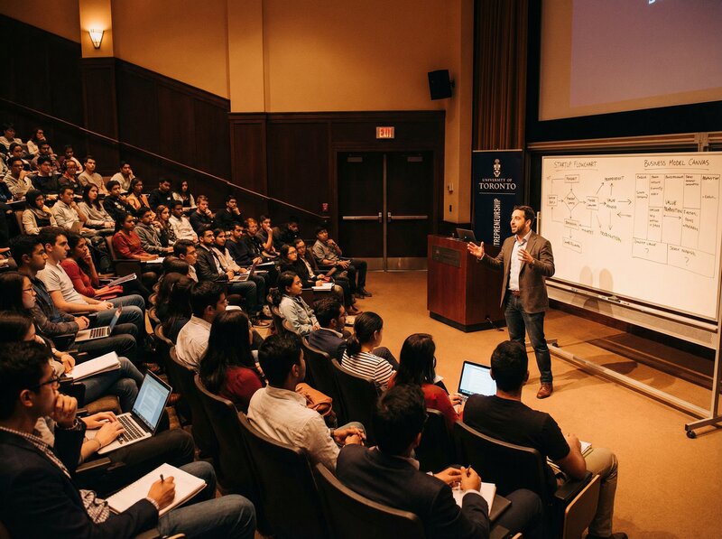 Dynamic university lecture on entrepreneurship with startup flowchart on whiteboard